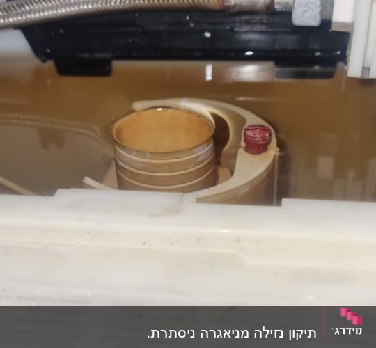 חלקי צנרת ומחבר מתכת בתוך מכל מים